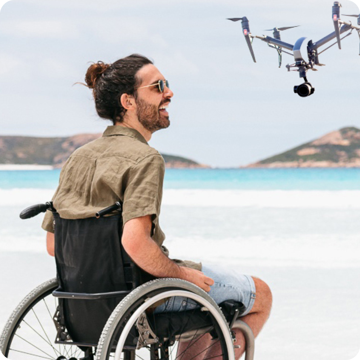 Guest speaker Jaimen Hudson pictured in a wheelchair at the beach with a drone in flight.