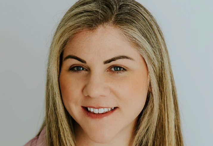 A head shot of a young blond woman wearing her straight hair down