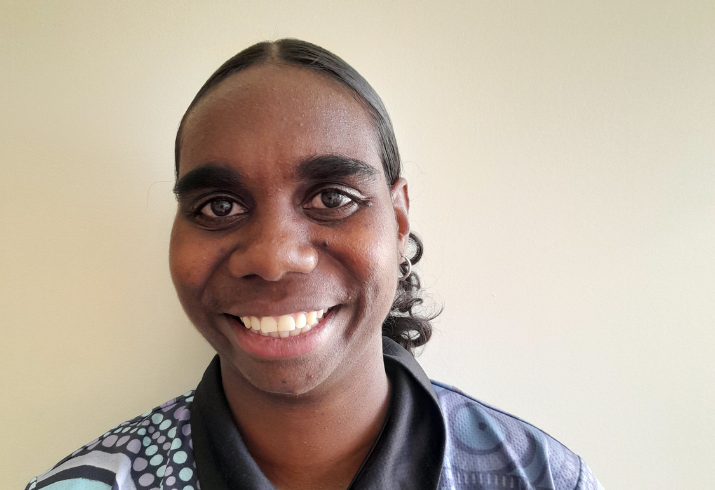 Head shot of a smiling young woman with black hair tied back