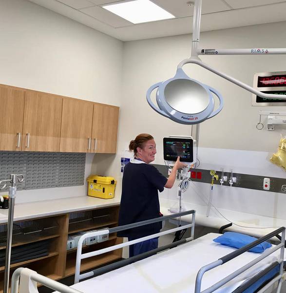 Clinician adjusting a hospital room.