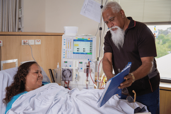 Aboriginal health worker discusses charts with patient