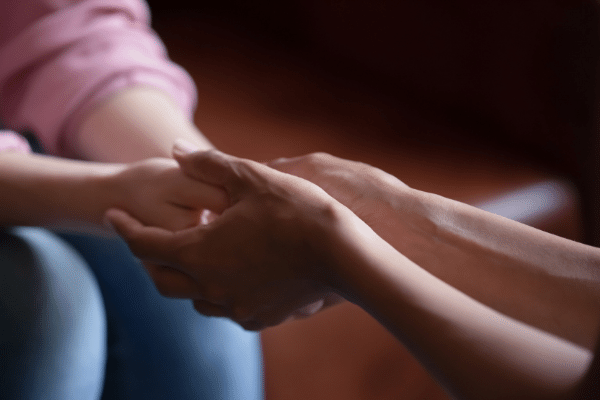Hands holding hands in show of emotional support