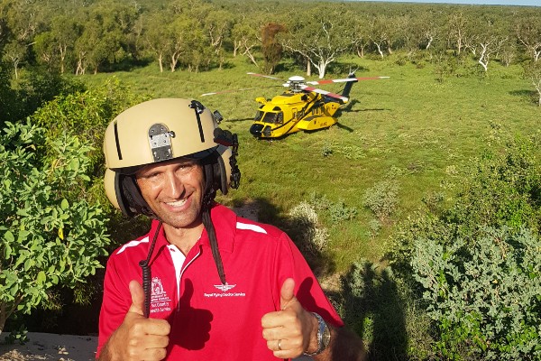 Dr Forster giving thumbs up with RFDS helicopter