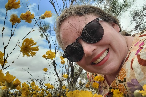 Dr Kelly Ridley in a field of yellow wildflowers