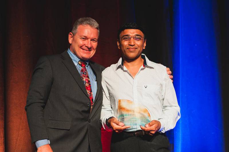 Dr Deshmukh (right) stands with his award after receiving it from Jeff Moffet (left)