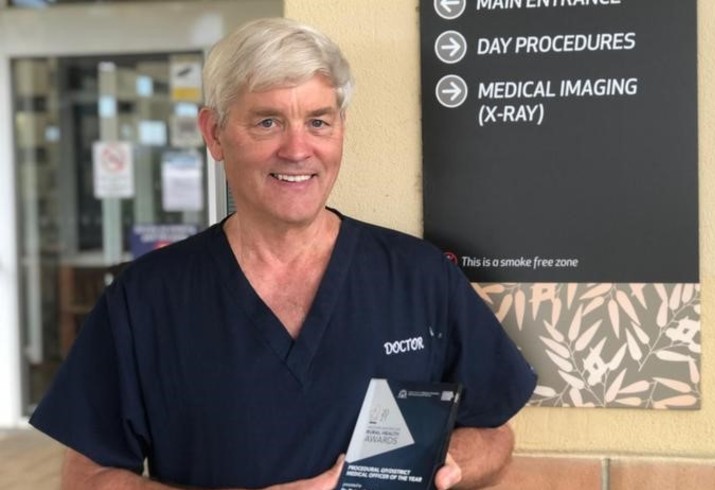 Dr Peter Smith with rural health award at hospital entrance