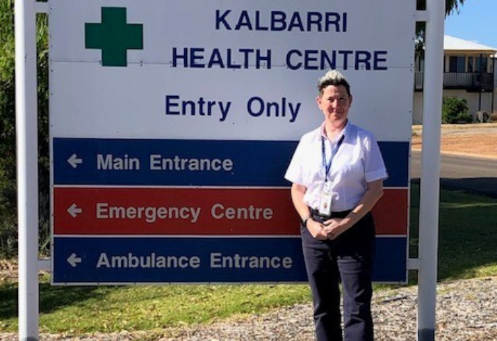 Claire String stands in front of the Kalbarri Health Centre sign in a white shirt, hands folded, smiling