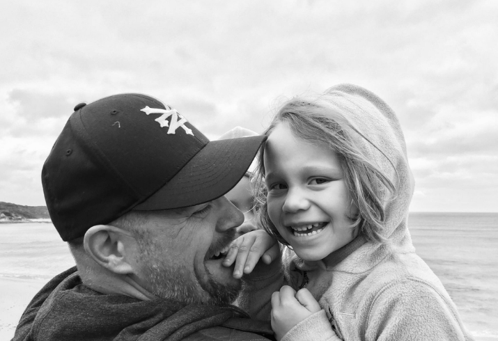 Dr Jason Pierce holding his children at the beach 