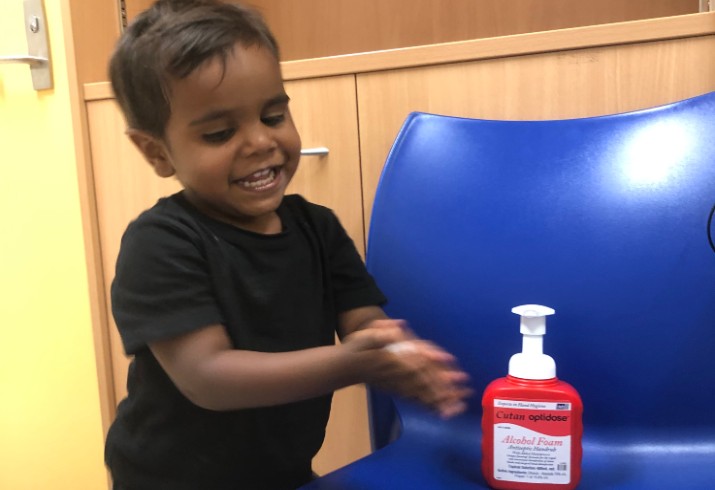 Young boy uses hand sanitiser