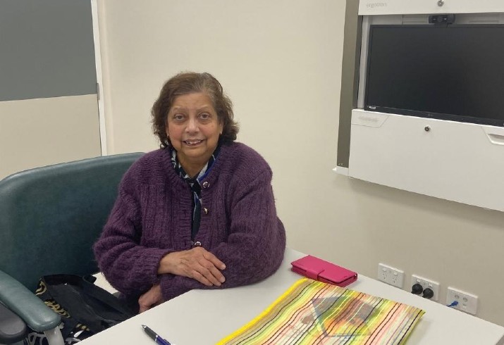 Patient Nisa in front of videocall equipment for telehealth appointment