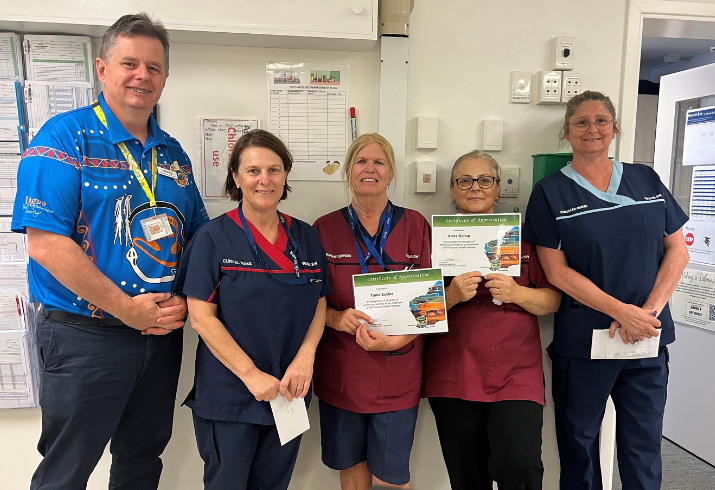 Operations manager and four healthcare staff holding certificates