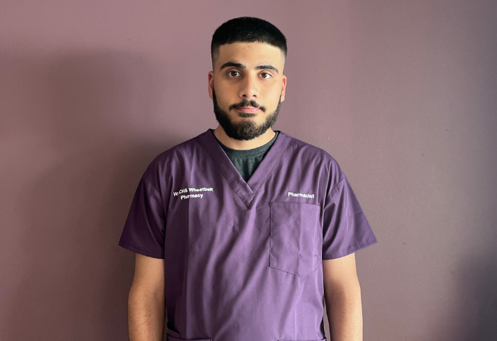 Photo of Yousif pharmacy intern wearing purple scrubs.