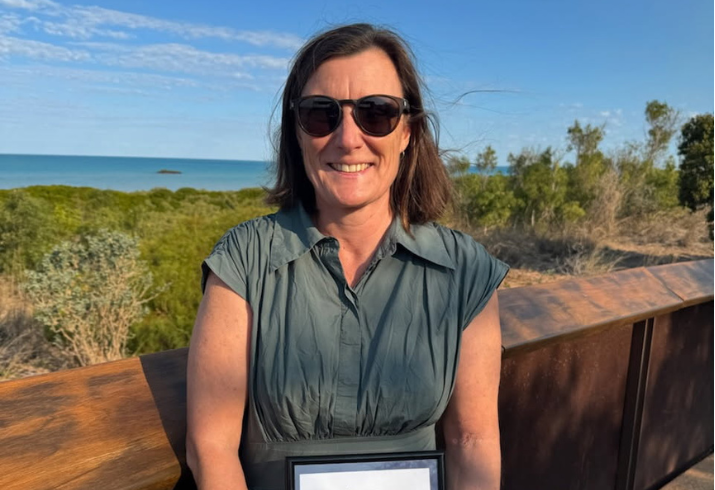 Emma outside holding award.