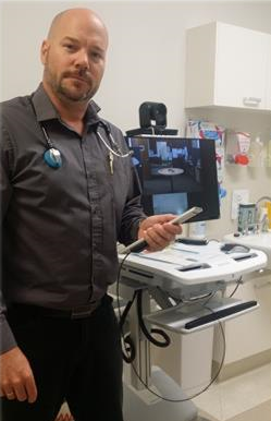 Dr Jason Pierce with one of the mobile TeleStroke videoconference units used by regional hospitals to allow neurologists in Perth to see country patients.