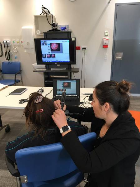 Performing digital otscopy.